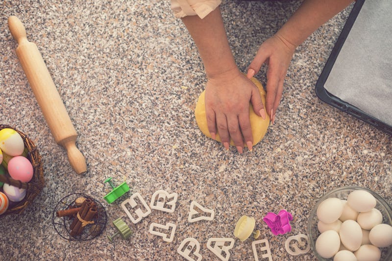 Young women preparing dough for homemade Easter cookies