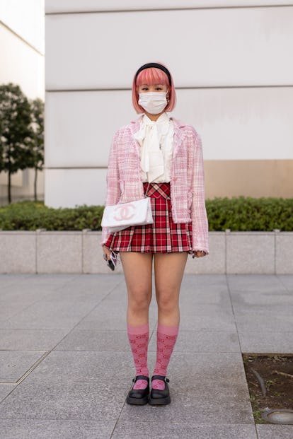 TOKYO, JAPAN - MARCH 15: A guest is seen on the street wearing pink check cardigan, white blouse, re...