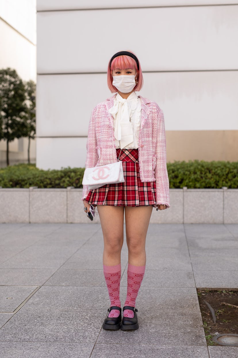 TOKYO, JAPAN - MARCH 15: A guest is seen on the street wearing pink check cardigan, white blouse, re...