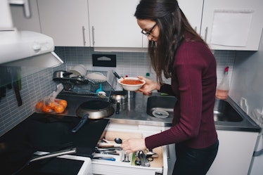 A woman in her kitchen recreates this tomato soup recipe on TikTok.