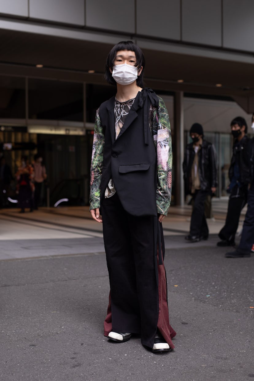 TOKYO, JAPAN - MARCH 20: A guest is seen on the street wearing a colorful design shirt, black vest, ...