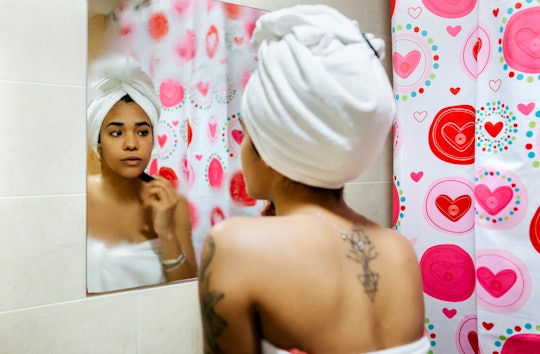 woman standing outside of shower with hair in towel