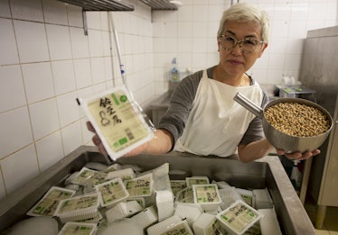 Japanese cook Chisa Ogawa, poses with packaged Tofu and soy beans ready to be processed, at her Suzu...
