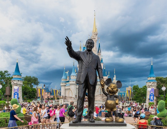 A Walt Disney and Mickey Mouse statue inside of the Magic Kingdom theme park . The Cinderella castle...