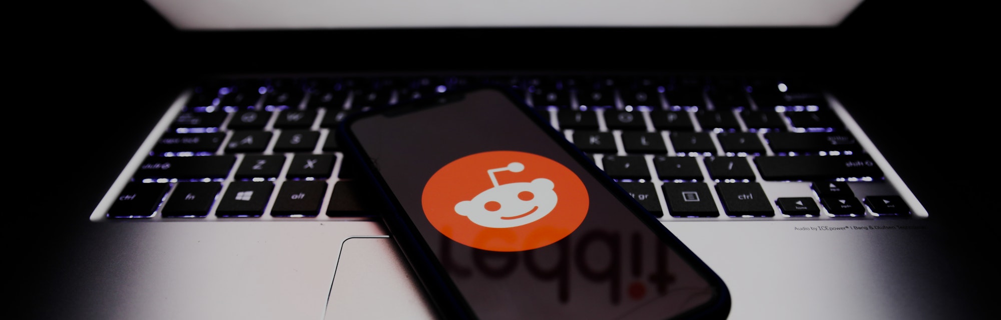 Reddit logos displayed on a phone and a laptop screens are seen in this illustration photo taken in ...