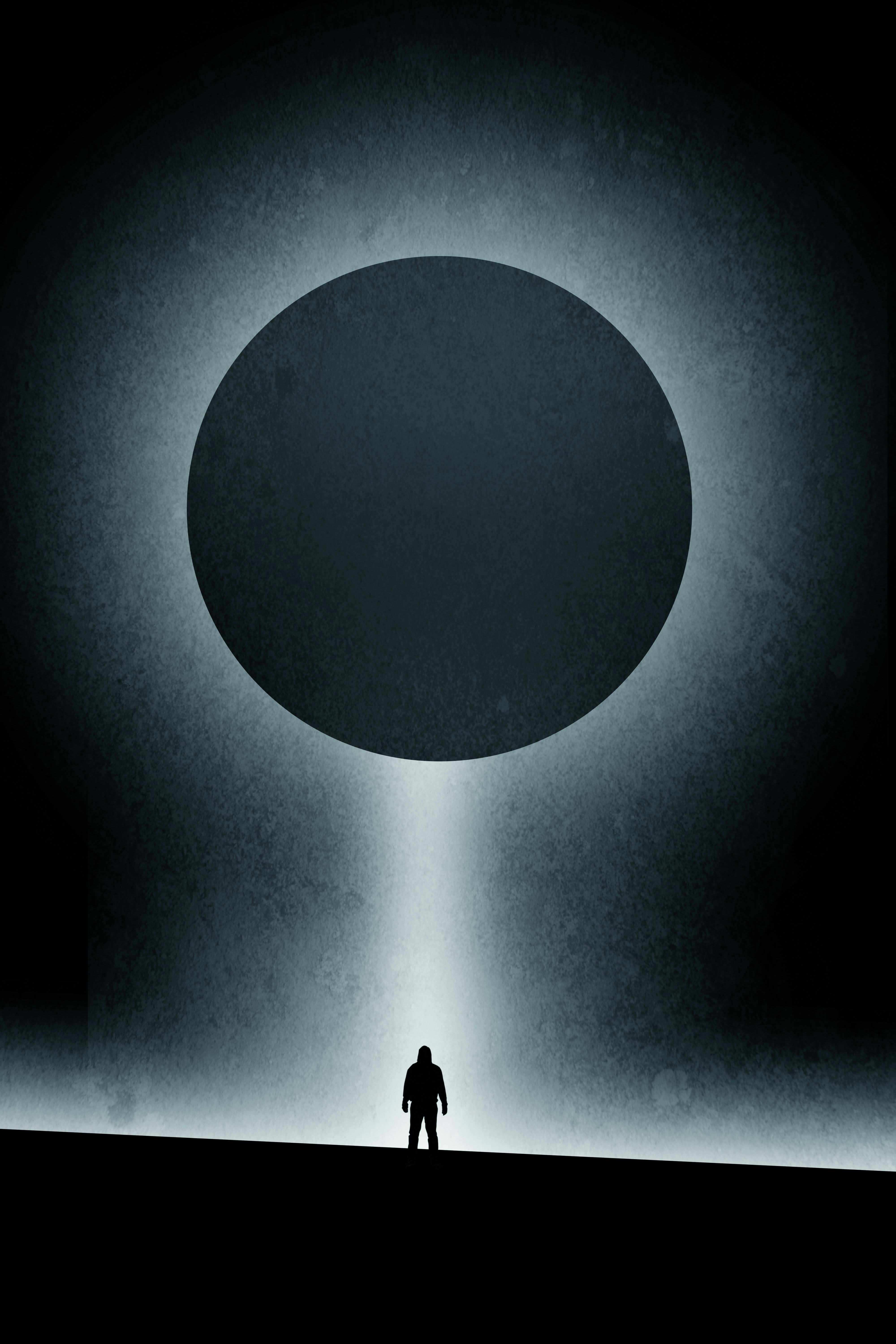 A minimal science fiction edit of a hooded silhouette of a figure of a man standing below a light be...