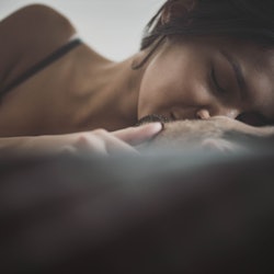Close up of young passionate couple kissing with their eyes closed in a bed. Copy space.