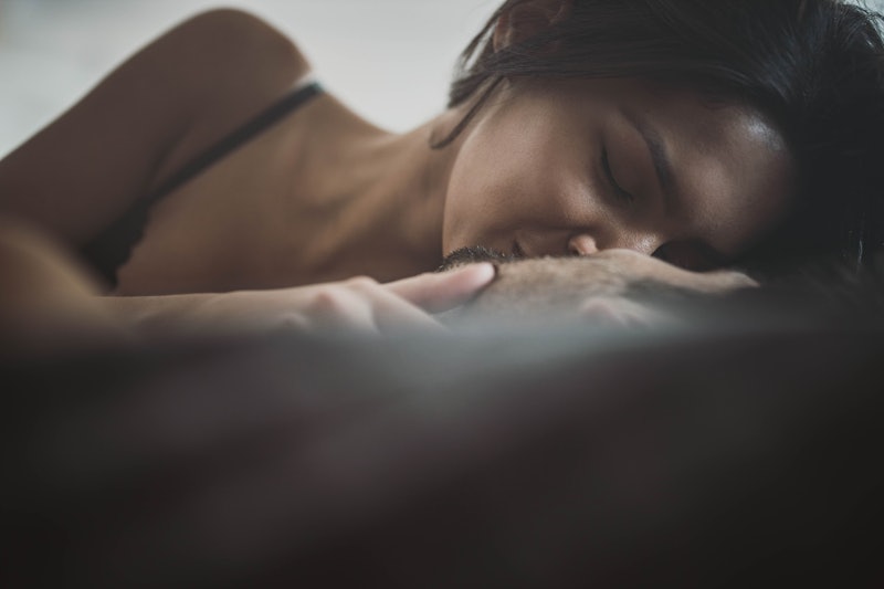 Close up of young passionate couple kissing with their eyes closed in a bed. Copy space.