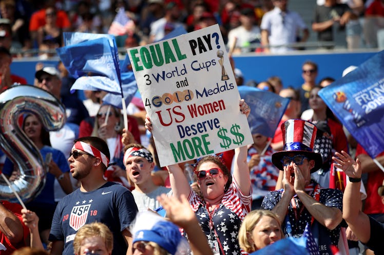 LYON, FRANCE - JULY 07: A USA fan holds a banner protesting the gender pay gap during the 2019 FIFA ...