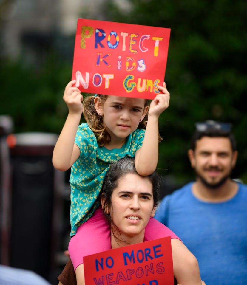 A woman holds her child  as she takes part in a rally of Moms against gun violence and calling for F...