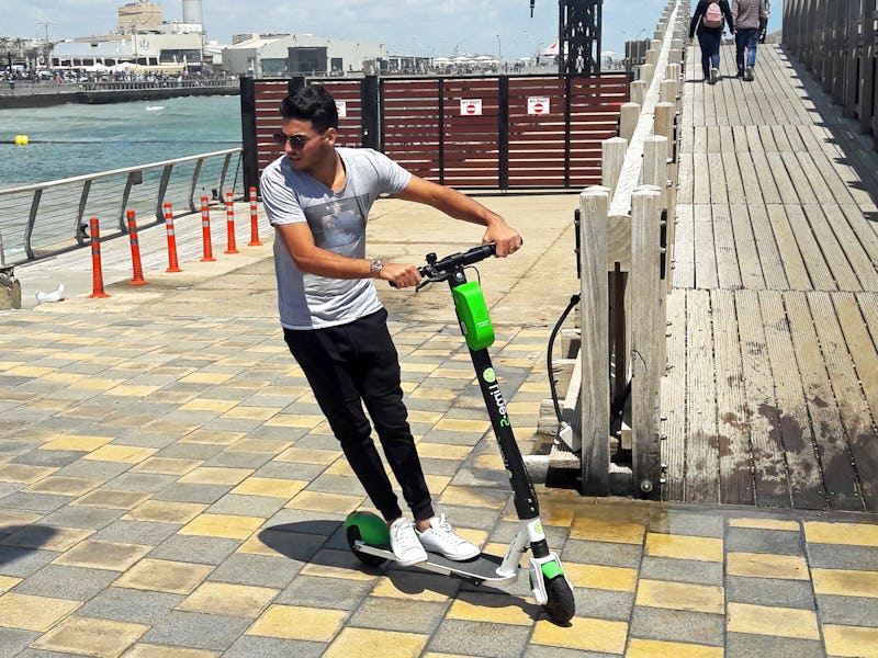 Young man riding a LIME electric scooter in the new Promenade of Tel Aviv. Due to good weather and s...