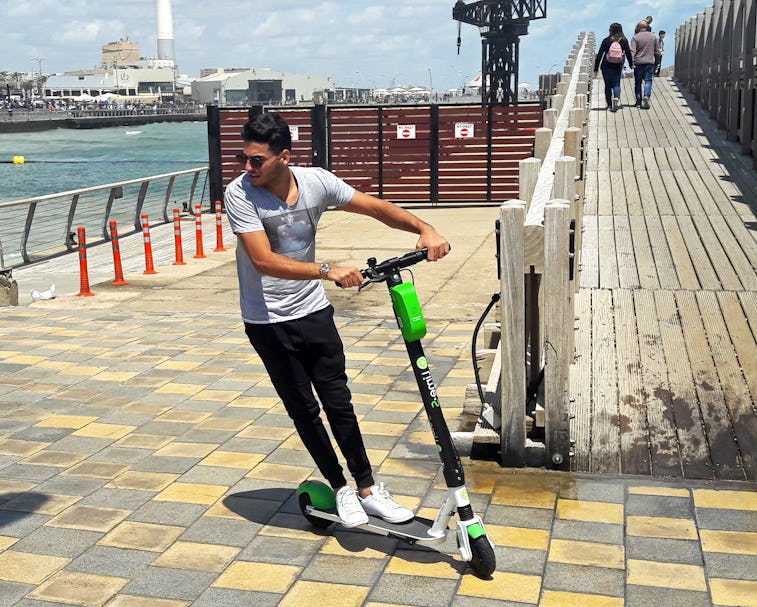 Young man riding a LIME electric scooter in the new Promenade of Tel Aviv. Due to good weather and s...