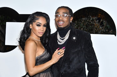 Saweetie in a black tulle dress and Quavo in a black turtleneck, blazer and silver chains