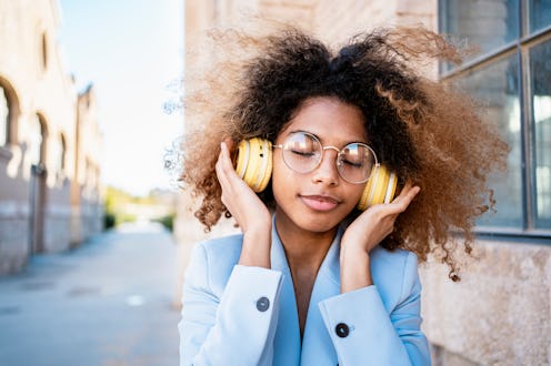 woman enjoying listening to music through headphones