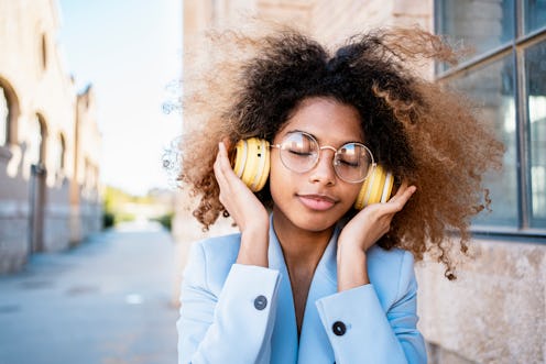 woman enjoying listening to music through headphones