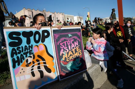 OAKLAND, CA - MARCH 23: Annie Hong, of Oakland, holds signs during an anti-Asian hate vigil at China...