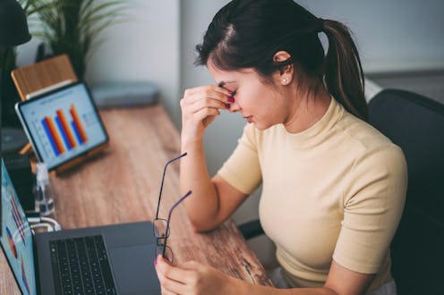 A woman deals with a headache linked to stress and anxiety.