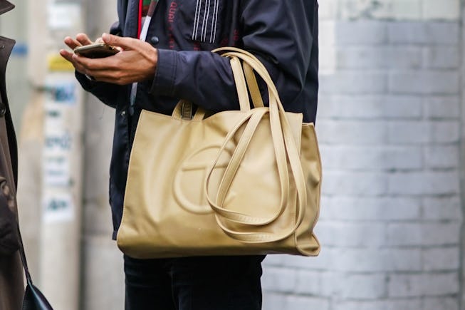PARIS, FRANCE - OCTOBER 01: A guest wears a beige leather Telfar logo bag, during Paris Fashion Week - Womenswear Spring Summer 2021, on October 01, 2020 in Paris, France. (Photo by Edward Berthelot/Getty Images)
