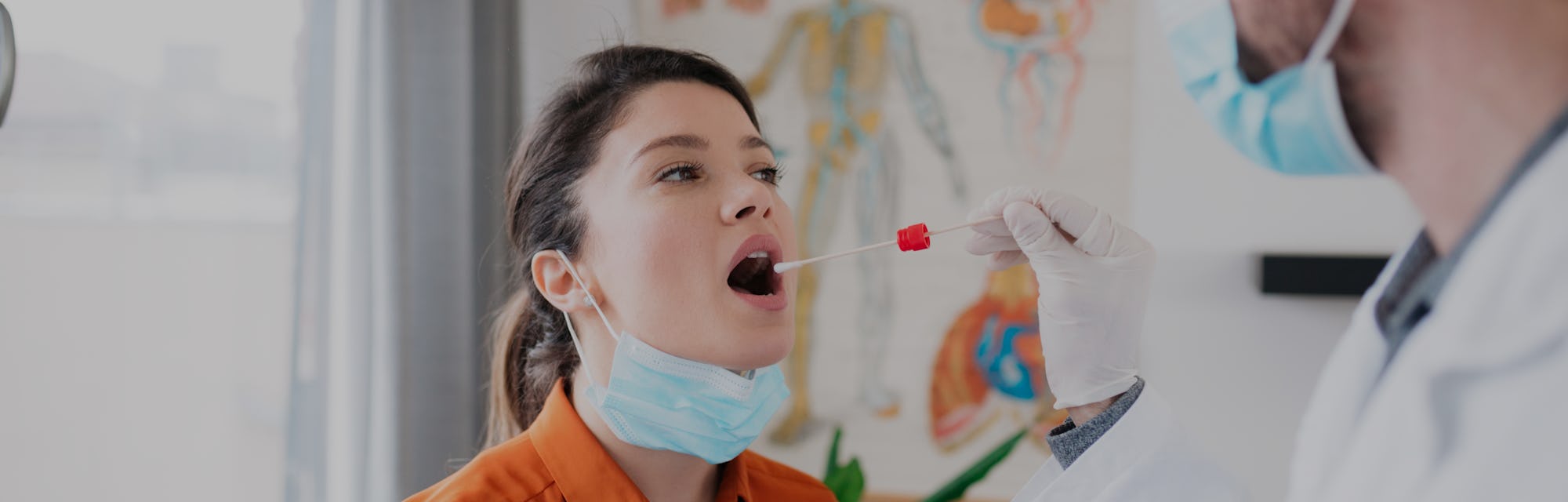 Young Caucasian female patient visiting her doctor's office and getting herself tested for coronavir...