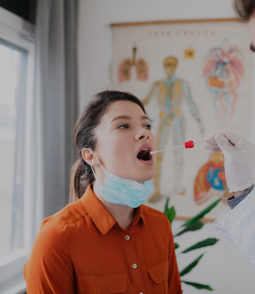 Young Caucasian female patient visiting her doctor's office and getting herself tested for coronavir...