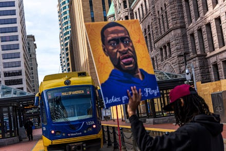 Demonstrators hold signs honouring George Floyd and other victims of racism as they gather during a ...