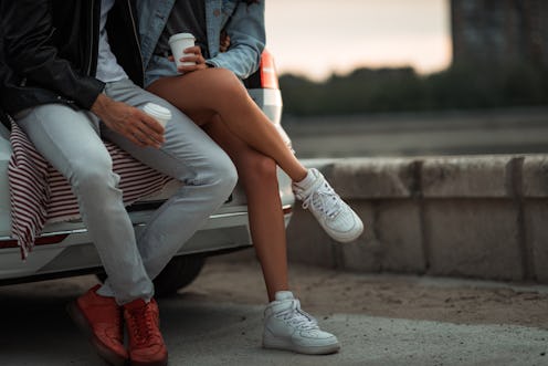 Close up of couple sitting in trunk of the car and enjoying sunset