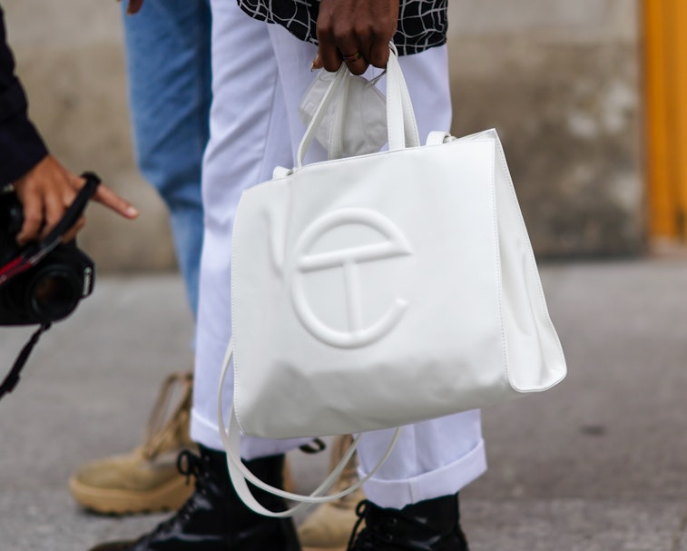 PARIS, FRANCE - OCTOBER 06: A guest wears a white Telfar leather bag, outside Louis Vuitton, during ...