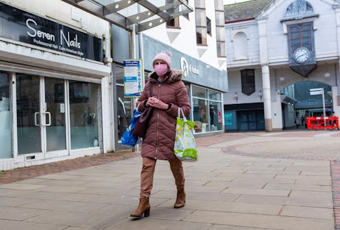 CARMARTHENSHIRE, UNITED KINGDOM - 2021/03/17: A woman wearing a mask as a preventive measure against...