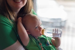 baby in st. patrick's day outfit on mom's lap