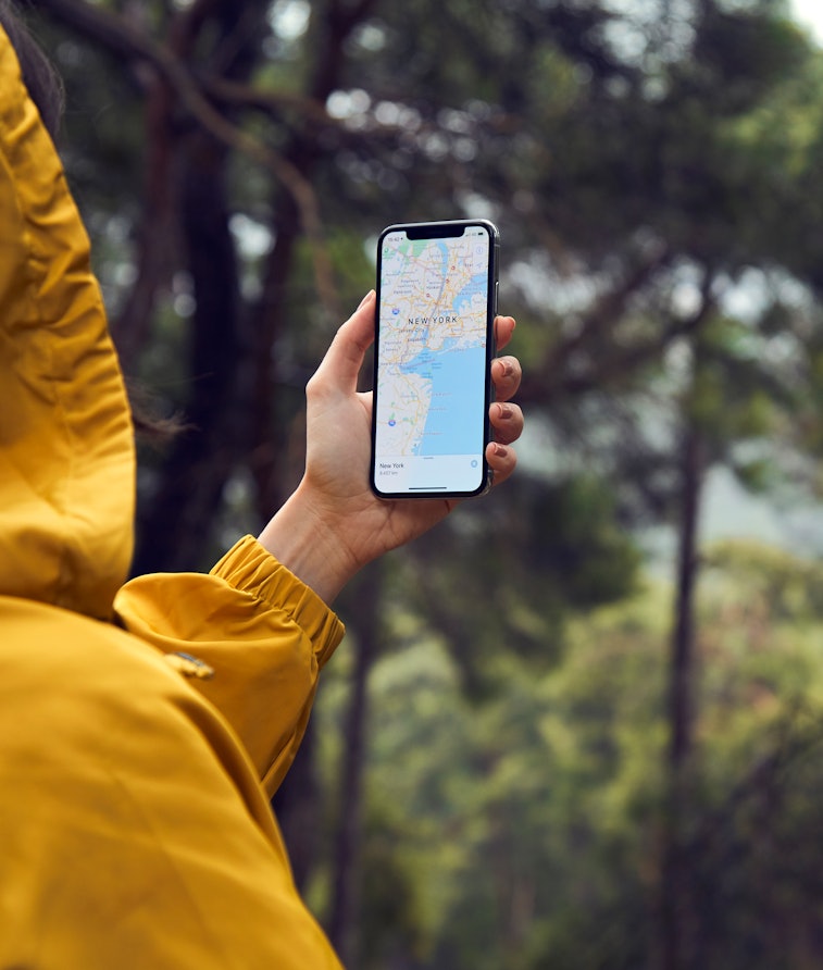 Istanbul, Turkey - January 25, 2019: Woman in the farm planning a route using a Google Maps application on Apple iPhone X. Google Maps is a most popular web mapping service for mobile provided by Google inc.