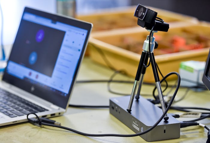 The teacher's computer and video camera to teach students attending class virtually are seen on a de...