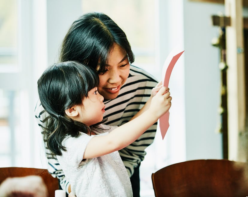 little girl giving mom a mother's day card