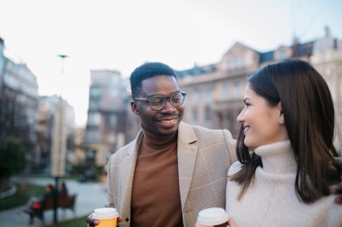 Happy young diverse romantic couple on a vacation, exploring the city on foot,  having fun and enjoy...