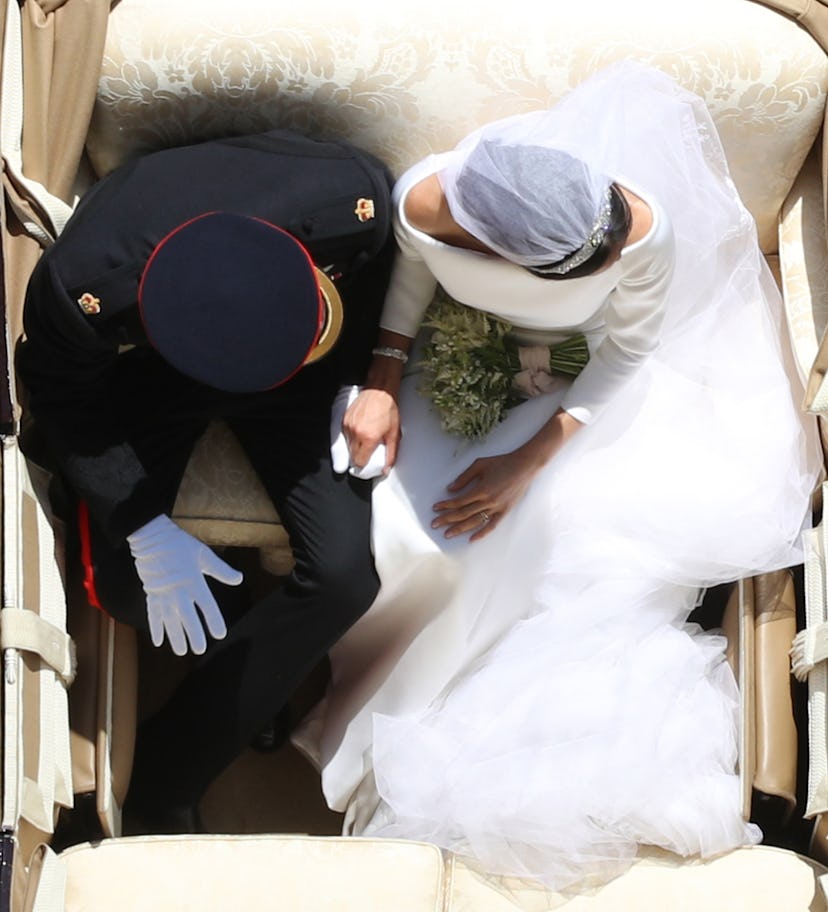 In the royal carriage the couple held hands on their wedding day.