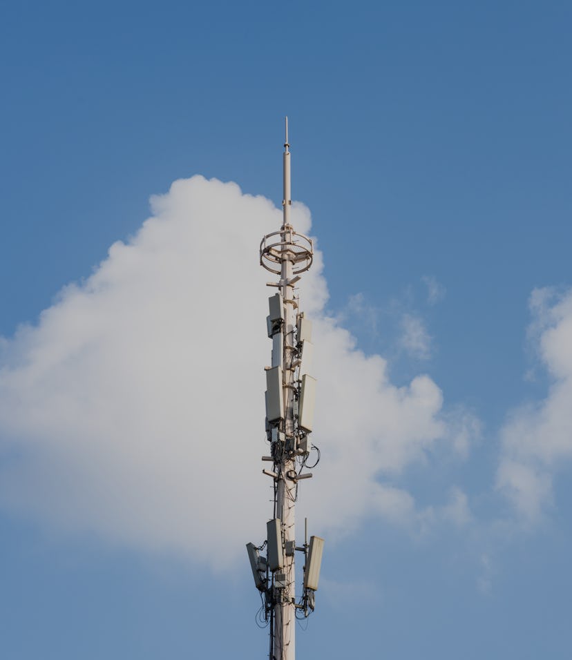 Cellular network tower in front of a blue sky.