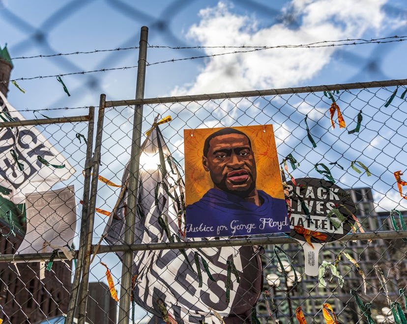 A poster with George Floyd's picture and a sign reads that "I Can't Breathe" hang from a security fe...