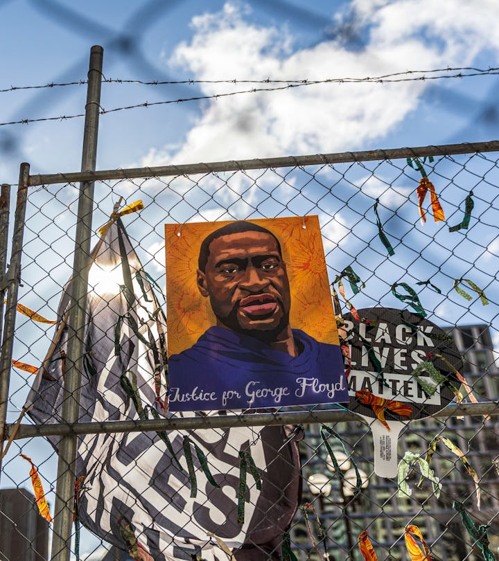 A poster with George Floyd's picture and a sign reads that "I Can't Breathe" hang from a security fe...