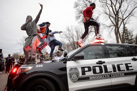 BROOKLYN CENTER, MN - APRIL 11: Men jumped on police vehicles near the site of an officer involved s...