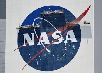 CAPE CANAVERAL, FLORIDA - MAY 20: Workers freshen up the paint on the NASA logo on the Vehicle Assem...