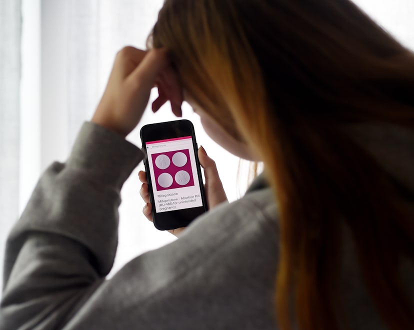 In this photo illustration, a person looks at an Abortion Pill (RU-486) for unintended pregnancy fro...