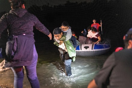 ROMA, TEXAS - APRIL 9: Boys walk onto shore after a smuggler rowed them across the Rio Grande at the...