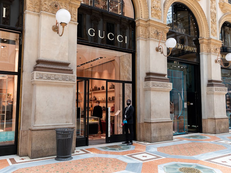 Staff members give hand-sanitizing gel and test customers temperature inside of Gucci store during t...