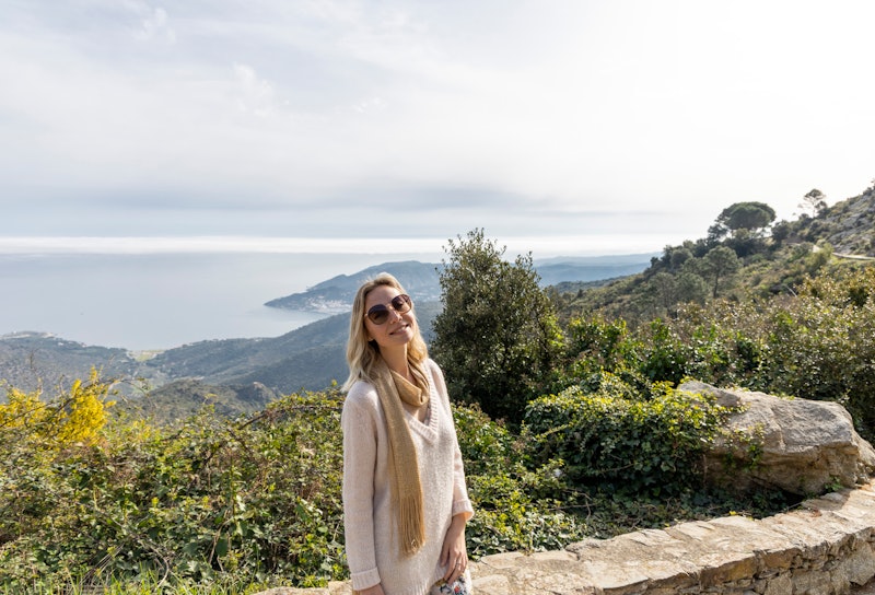Young blonde woman, Relaxed on the mountain with beautiful sea view