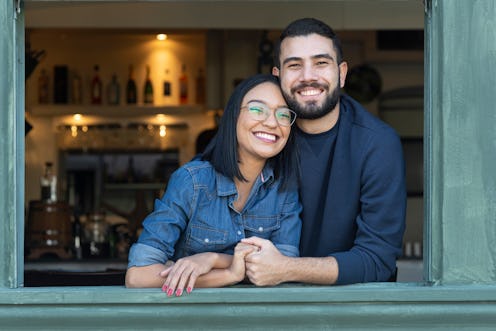 Portrait image of a romantic young couple by an open window