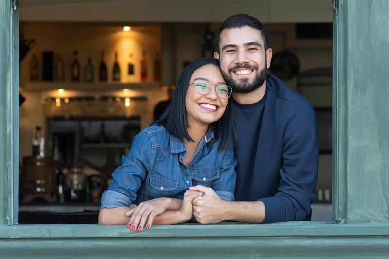 Portrait image of a romantic young couple by an open window