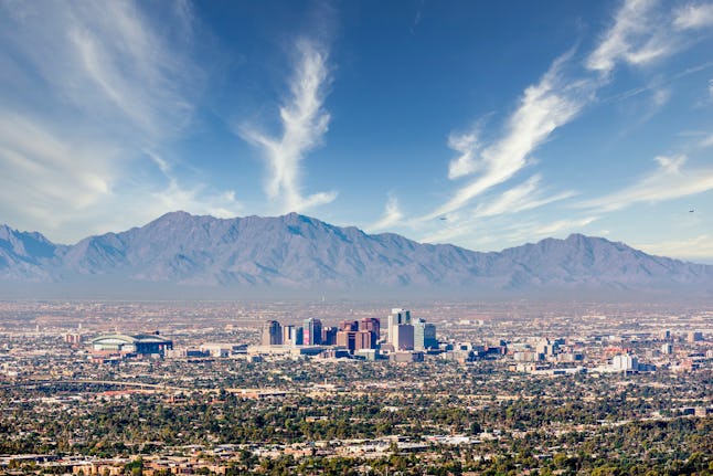 Looking south west to the tall buildings of Downtown Phoenix and South Mountain Preserve from Camelback Mountain in Maricopa County Arizona USA