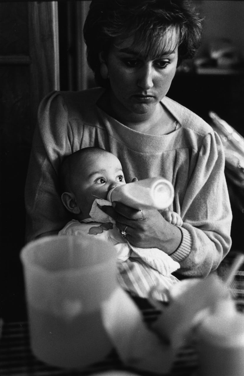 A mother feeding her baby from a bottle in Teeside, March 1986. (Photo by Steve Eason/Hulton Archive...