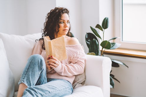 Woman read interesting book at sofa in living room