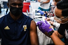 Pharmacy student Jason Rodriguez (R) administers a Covid-19 vaccine to Larry Grier at the Christine ...