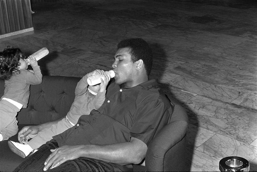 Muhammad Ali drinks from the baby botlle of his daughter, Zurich 1971   (Photo by Blick Sport/RDB/ul...